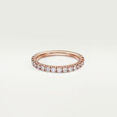 a rose gold wedding band with five round diamonds on the top and bottom, set in 18k rose gold