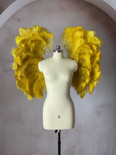 a white mannequin with yellow feathers on it