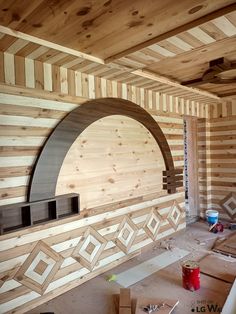 an unfinished room with wood paneling and a fireplace