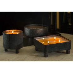 three candles sitting on top of a wooden table