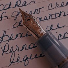 a fountain pen sitting on top of a piece of paper with cursive writing