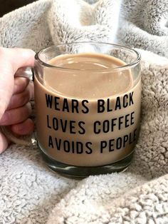 someone is holding a coffee mug that says, wears black loves coffee avoid people