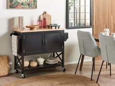 a small kitchen island in the middle of a room with chairs and a rug on the floor