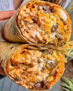 two burritos are stacked on top of each other with cheese and meat in them