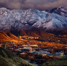 the mountains are covered with snow in this view from an overlook looking down on town