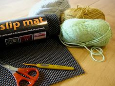 a pair of scissors, yarn and knitting needles on a mat