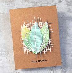 a handmade card with a green leaf on the front and white lines in the back