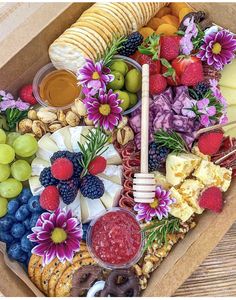 a box filled with lots of different types of cheeses and fruit on top of it