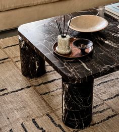 a marble coffee table with candles and plates on it