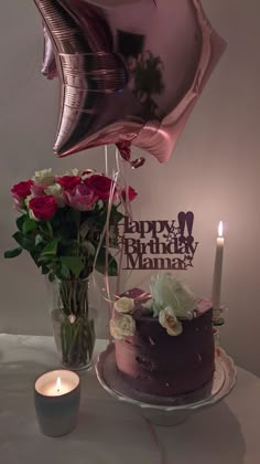 a birthday cake on a table with balloons and flowers