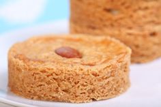 two small cakes sitting on top of a white plate next to each other with nuts in the middle