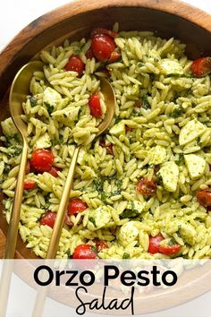 a bowl filled with pesto pasta and two spoons on top of the bowl