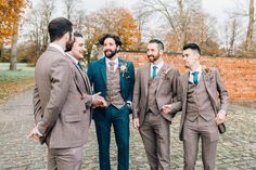 a group of men in suits standing next to each other on a cobblestone road