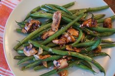 a white plate topped with green beans and mushrooms