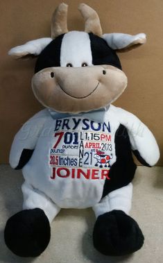 the stuffed cow is wearing a white shirt with red lettering on it's chest