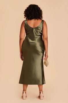 a woman in a green dress with her back to the camera