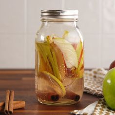 a glass jar filled with sliced apples and spices