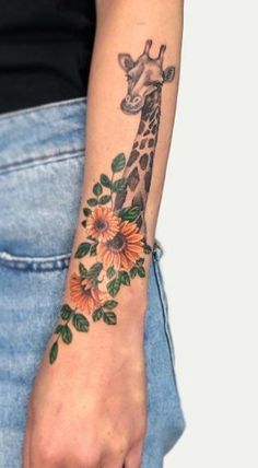 a giraffe with sunflowers and leaves on it's arm is shown