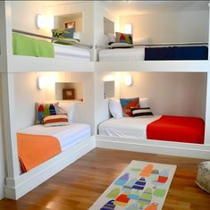 three bunk beds in a room with wood flooring and white walls, one is brightly colored