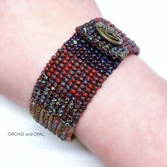 a close up of a person's arm wearing a beaded bracelet