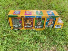 an unopened box with four different animal faces on it sitting in the grass