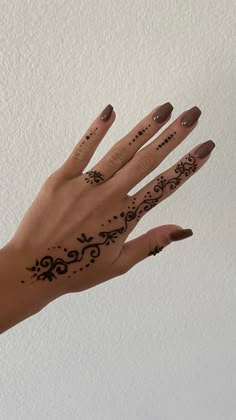 a woman's hand with henna tattoos on it