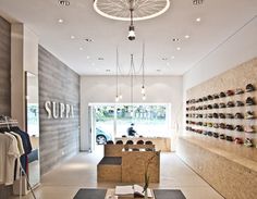 the inside of a shoe store with lots of shoes hanging on the wall and shelves