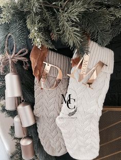 christmas stockings hanging from a tree with gold and silver ornaments around them on a fireplace mantel