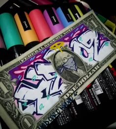 a dollar bill sitting next to markers and crayons