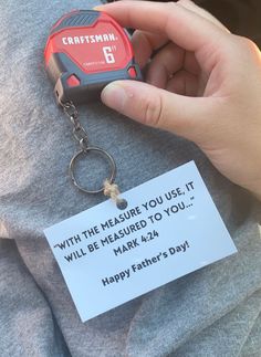 a person holding a keychain with a happy father's day message on it