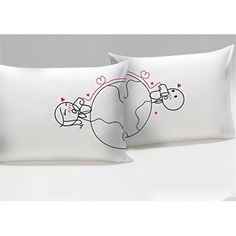 two pillow cases with hearts on them and an earth globe in the middle one is white