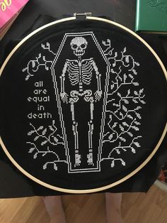 a cross - stitch skeleton is on the floor next to some books