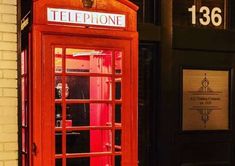 a red phone booth in front of a building