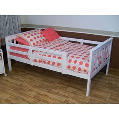 a white bed frame with pink and orange pillows