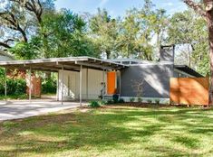 a modern house in the middle of a park with lots of trees and grass around it