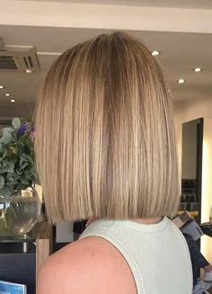 the back of a woman's head with short blonde hair and bangs in a salon