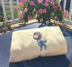 an embroidered pillow on top of a blue table