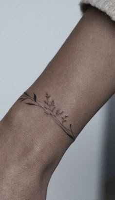 a woman's arm with a tattoo on it that has flowers growing out of it