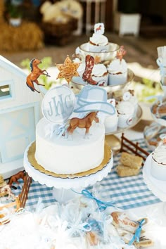 a table topped with cakes and cupcakes covered in frosting