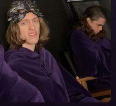 two people in purple robes sitting down and one is wearing a silver headdress