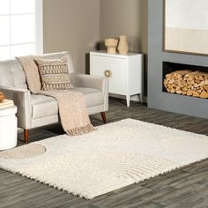 a living room with a chair, rug and fire place