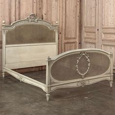 an antique white bed with ornate headboard and foot board is shown in front of wooden paneled walls