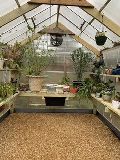 an indoor greenhouse filled with lots of plants and potted plants in pots on shelves