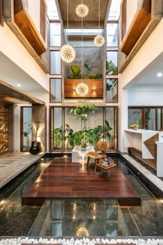 a living room filled with lots of furniture next to a tall ceiling mounted planter