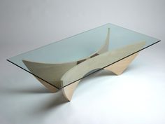 a glass and wood coffee table with curved design on the top, against a white background