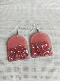 These beautiful earrings are made out of epoxy resin and Glitter. Glitter Red Earrings For Gifts, Red Glitter Earrings For Gift, Pink Resin Earrings For Party, Resin Jewelry With Matching Earrings For Party, Party Earrings With Resin Ear Wire, Party Earrings With Ear Wire In Resin, Pink Glitter Resin Jewelry, Resin Jewelry With Glitter For Gift, Glitter Resin Jewelry As A Gift