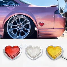 three heart shaped lights are shown on the side of a pink car and one is yellow