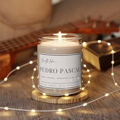 a candle sitting on top of a table next to a guitar