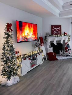 a living room decorated for christmas with fireplace and stockings on the mantel, tv above fire