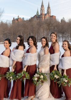 a group of women standing next to each other in front of a snow covered field